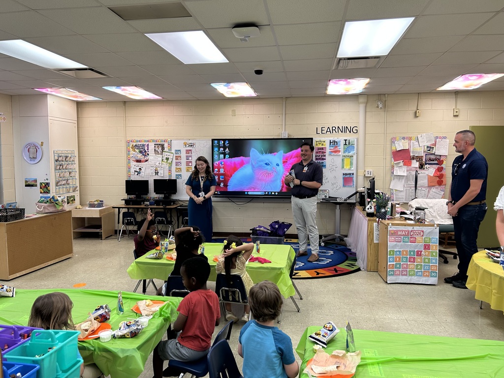 PreK class looking at presentation by a man and a woman