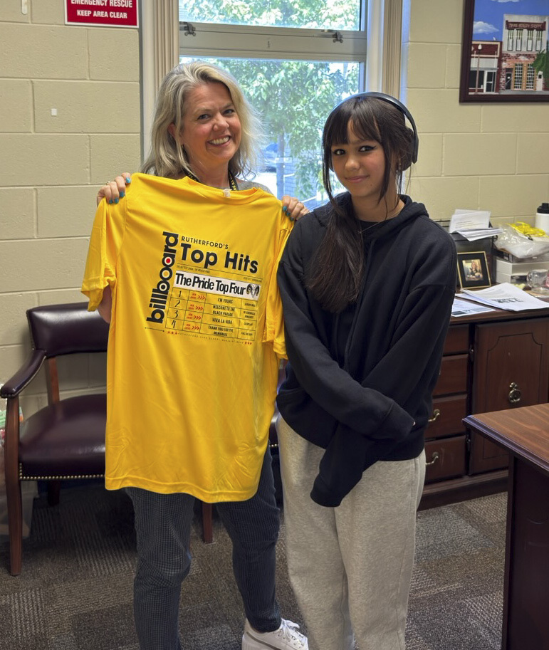 Band member presents a show shirt to Mrs. Messer