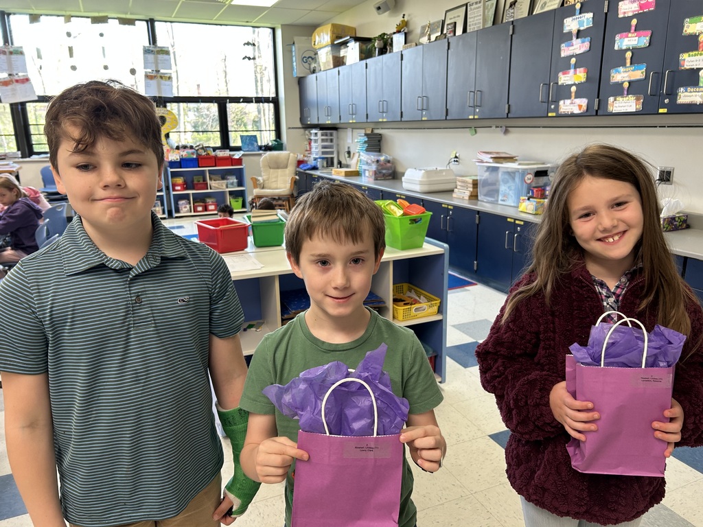 A photo of three Normandy military-connected students holding purple goody bags.
