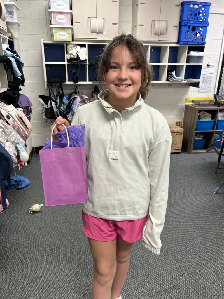A photo of a Normandy military-connected student holding a purple bag.