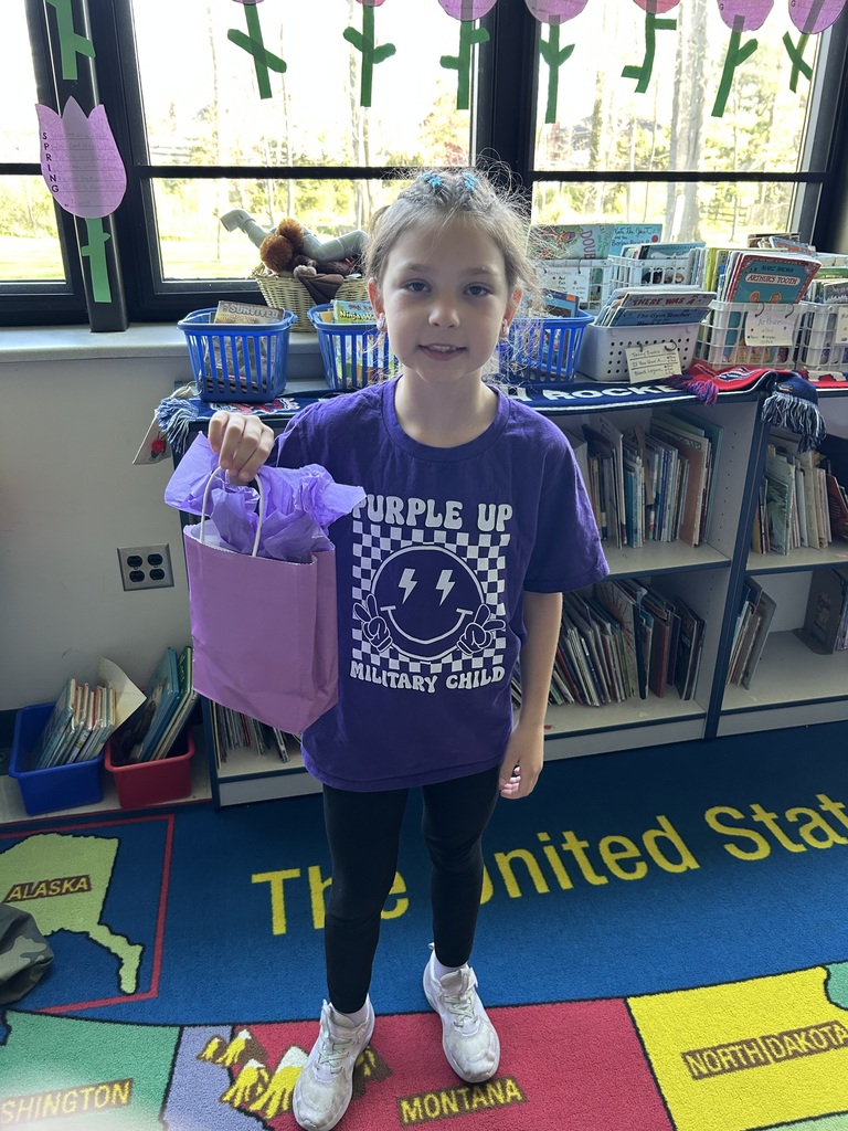 A photo of a Normandy military-connected student holding a purple bag.