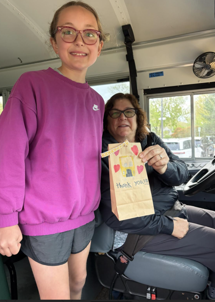 School Bus Driver Appreciation Day 2026 with a student presenting a goody bag to a bus driver.