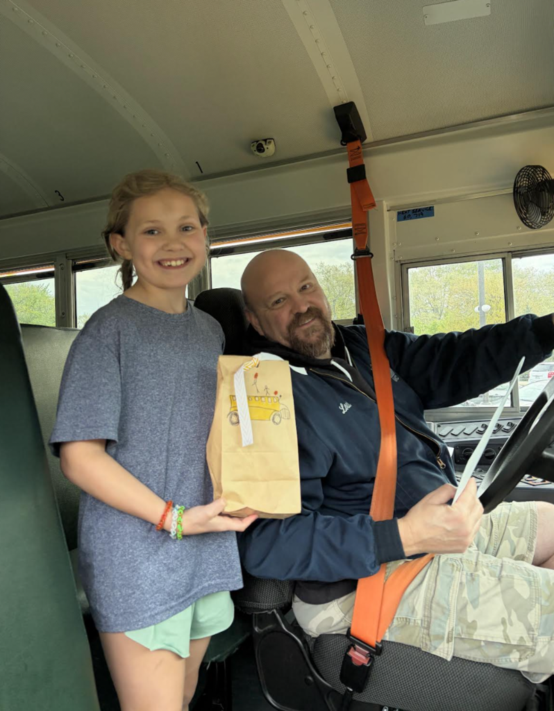 School Bus Driver Appreciation Day 2026 with a student presenting a goody bag to a bus driver.