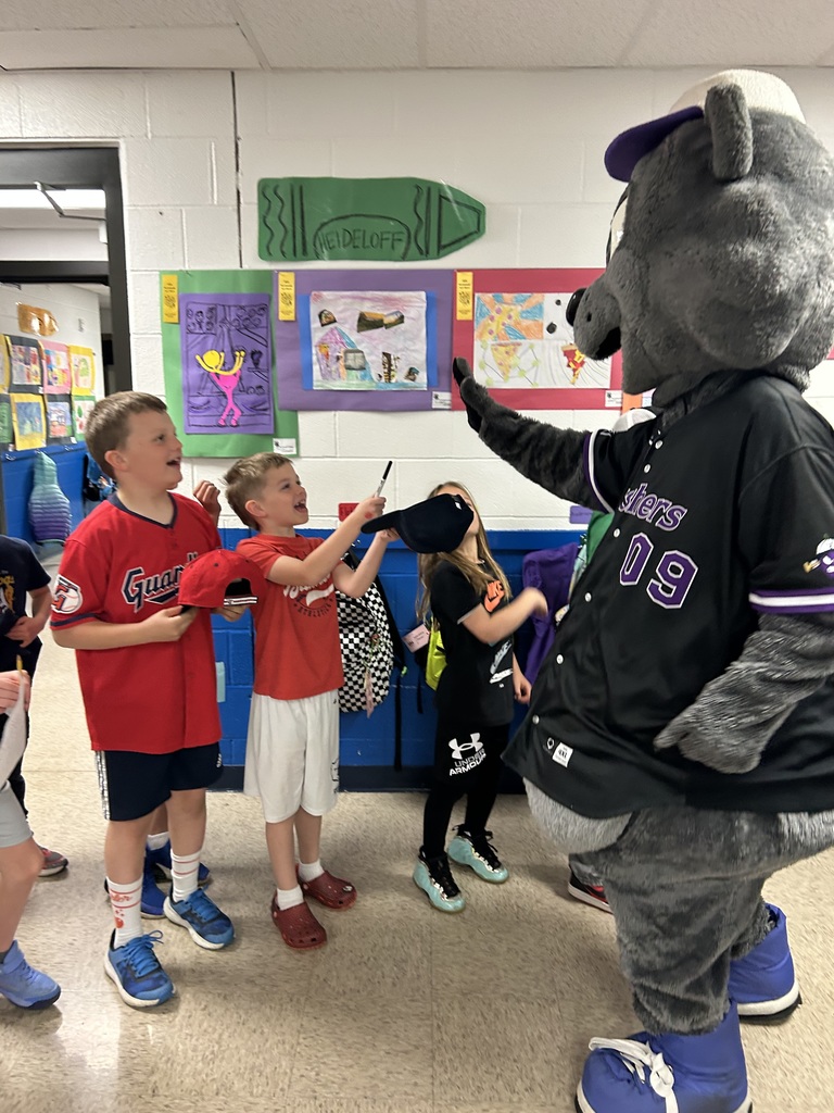 Crushers baseball mascot Stomper is shown with students  in the hallway of Normandy School in Bay Village.