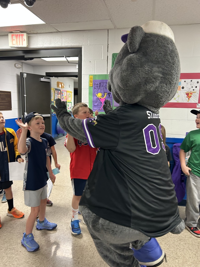 Crushers baseball mascot Stomper is shown with students  in the hallway of Normandy School in Bay Village.