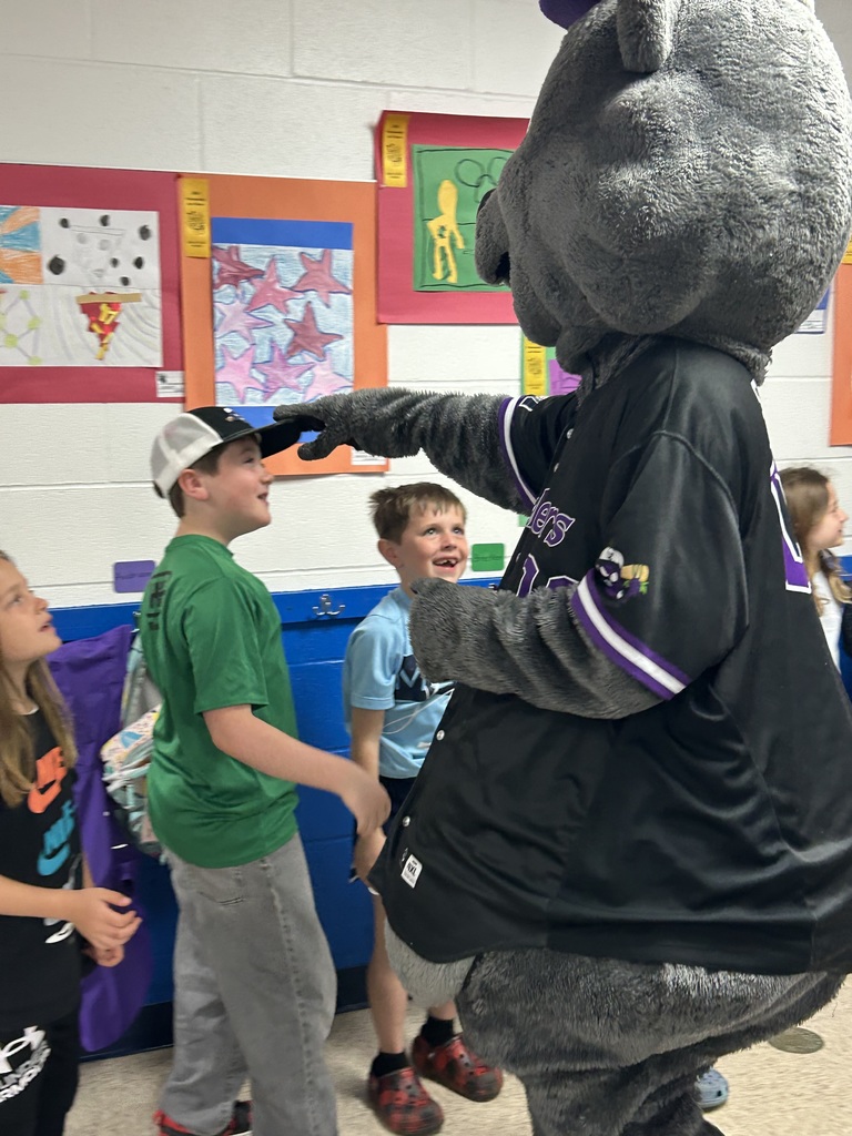 Crushers baseball mascot Stomper is shown with students  in the hallway of Normandy School in Bay Village.