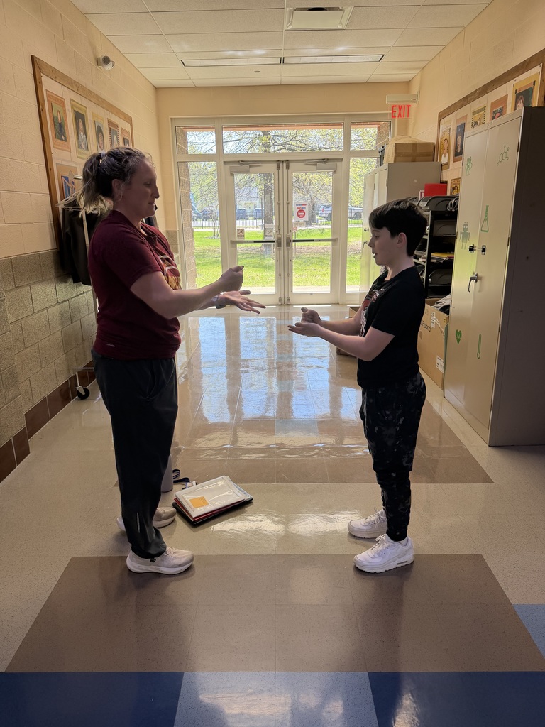 Rock paper scissors photo at bay middle school with teacher and student.