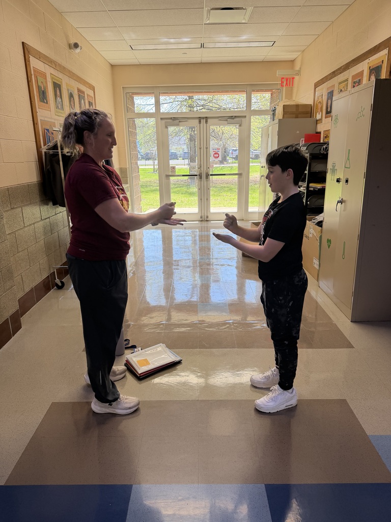 Rock paper scissors photo at bay middle school with teacher and student.