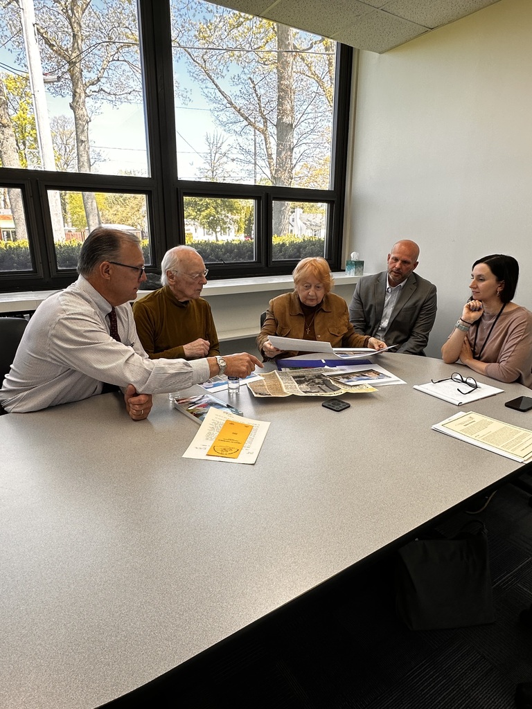 Former Glenview Center Director Carol Ball is pictured with her husband and current district administrators looking at archived news clips.
