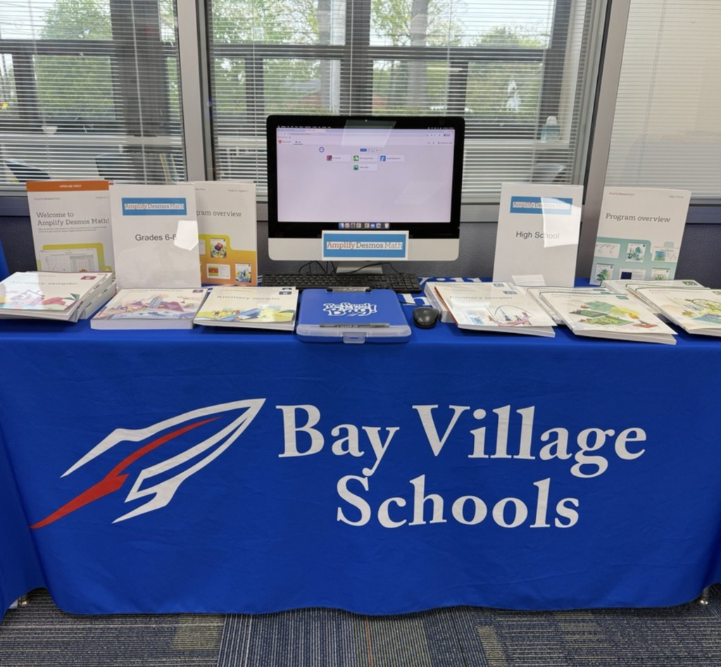 Math curriculum materials on a table with a desktop computer. 