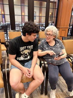 Bay High School Tech Club at Normandy Senior Living facility, with a student and a resident seated.