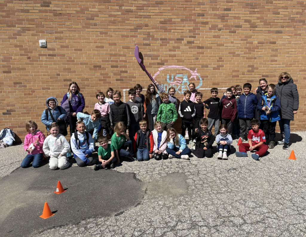 Glenview Center students celebrating sports week before summer break, standing against a brick wall.