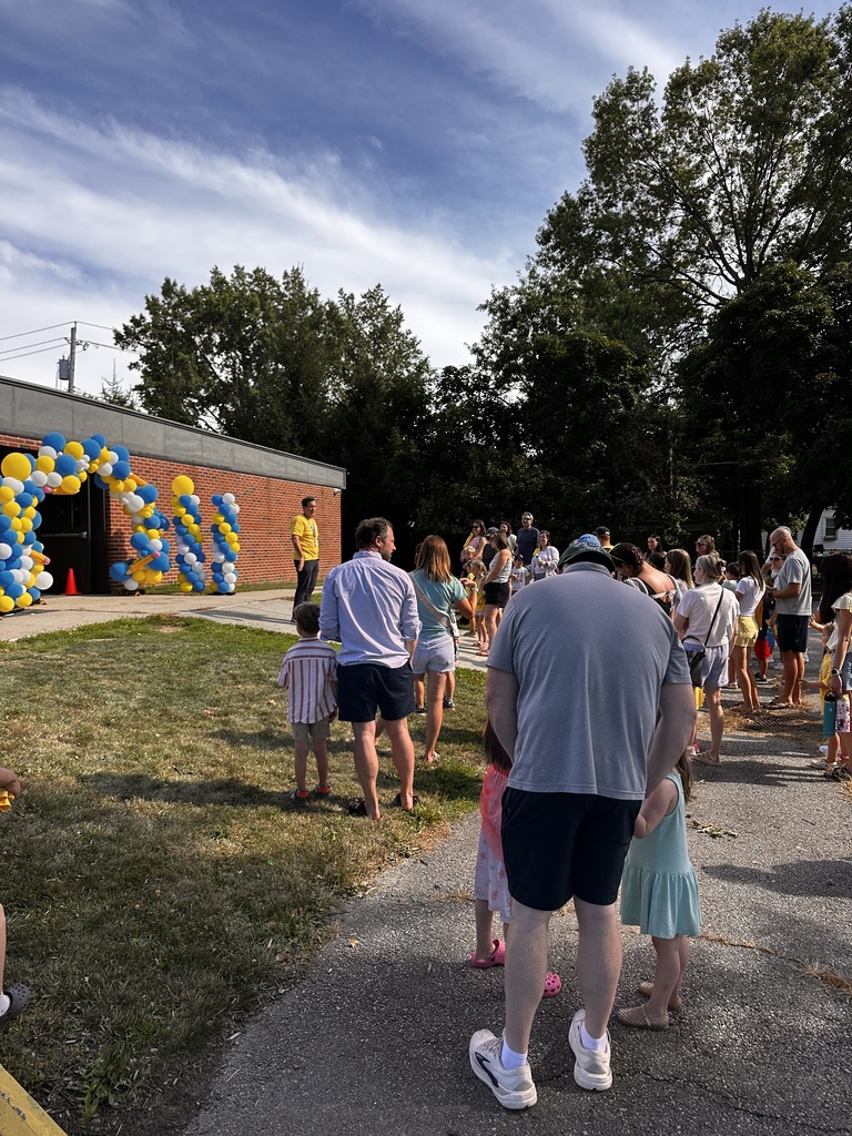 Parents and their kindergarten students listen to Principal Dan Sebring speak while standing on the playground.