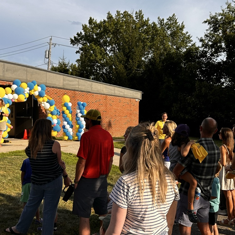 kindergarten parents listen to the principal, making some announcements on the playground