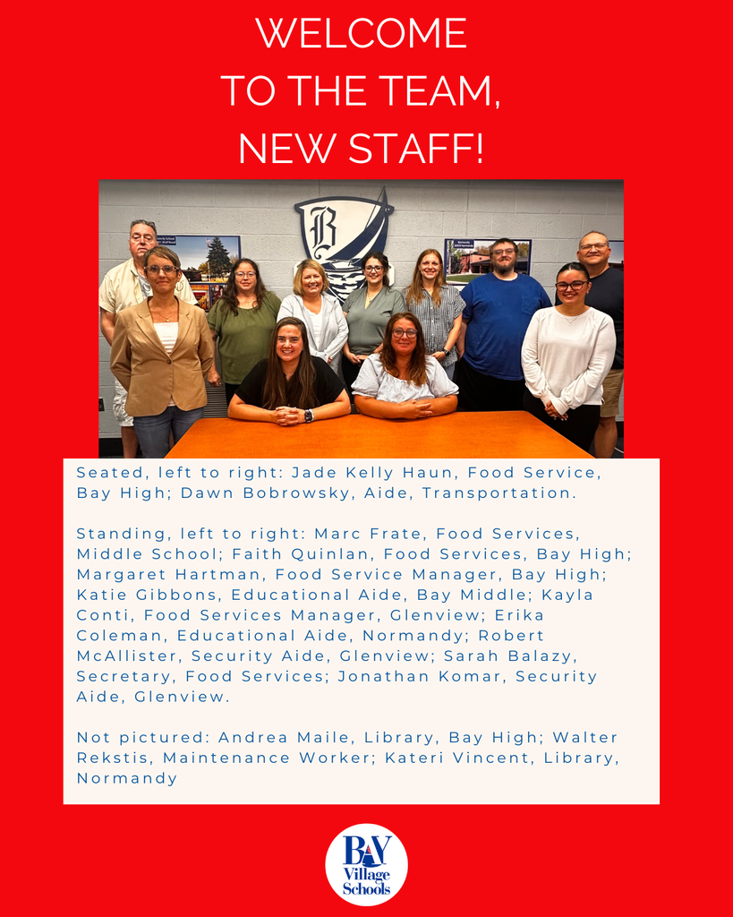 new staff for the 2026-27 school year photo with 12 people seated and standing around a desk during orientation.