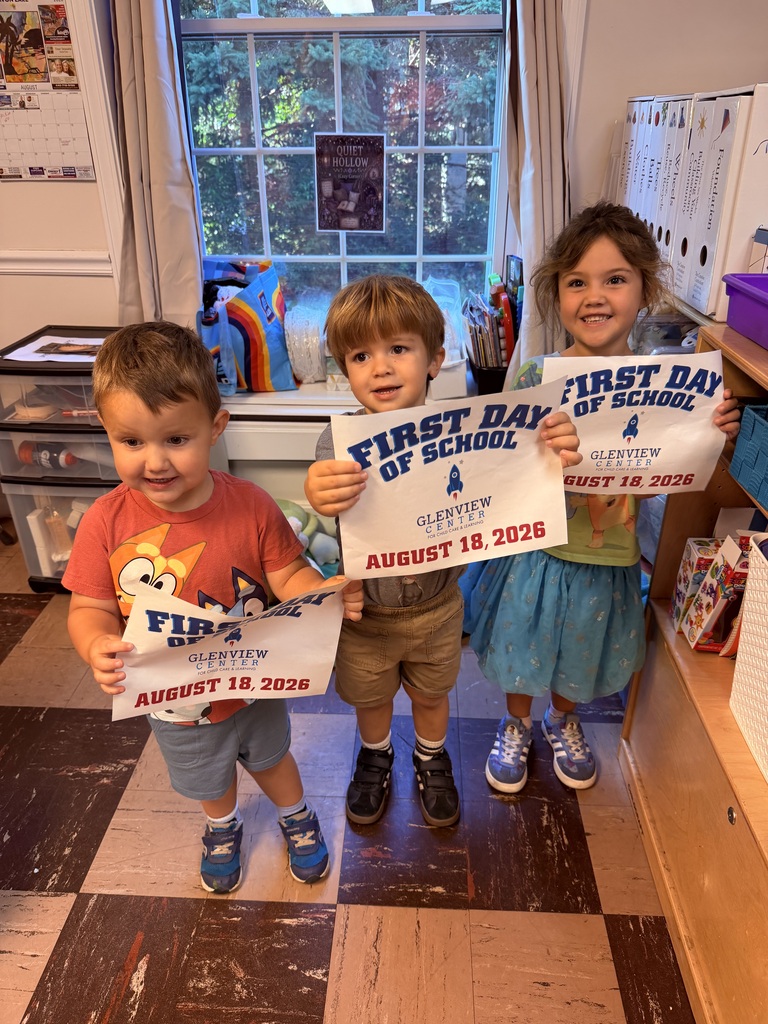 Three preschoolers holding up first day of school signs.