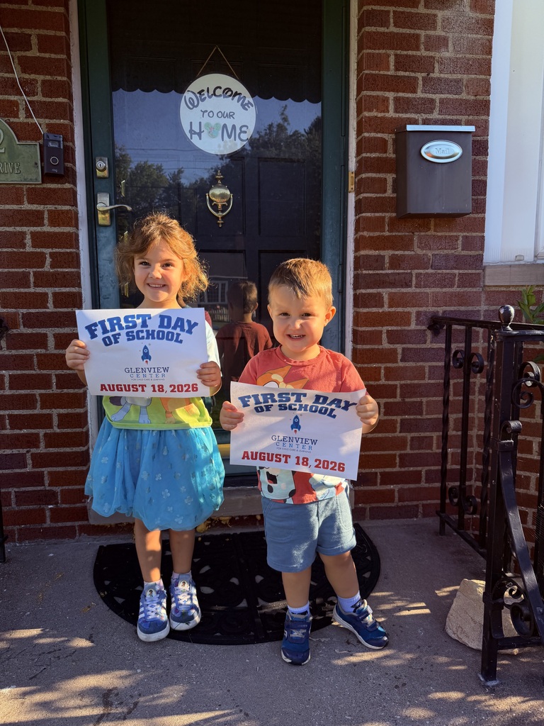 Two preschool students on their front porch with first day of school signs.