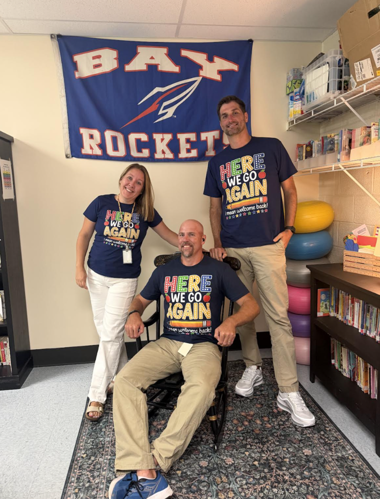 Three Westerly Elementary School teachers pose for a first day of school photo. Two are standing and one is seated.