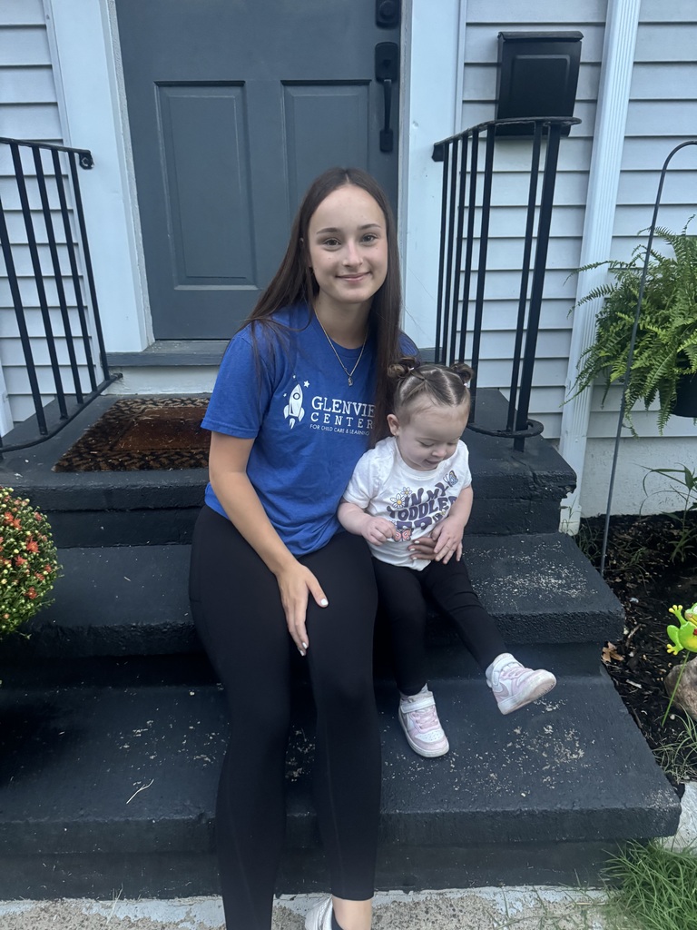 First day of school photo with a mom and daughter seated on their front porch.