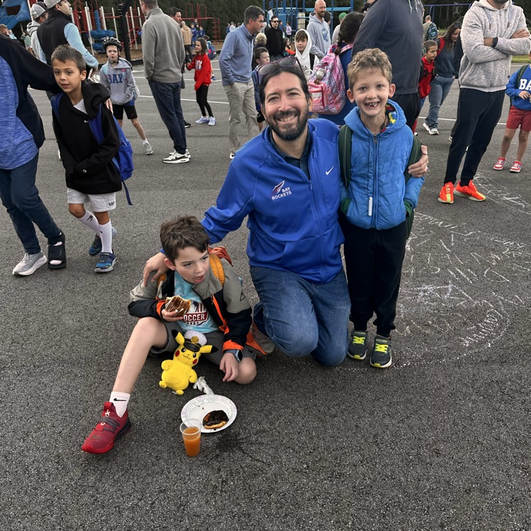 A man and his two sons arriving at school for a morning event