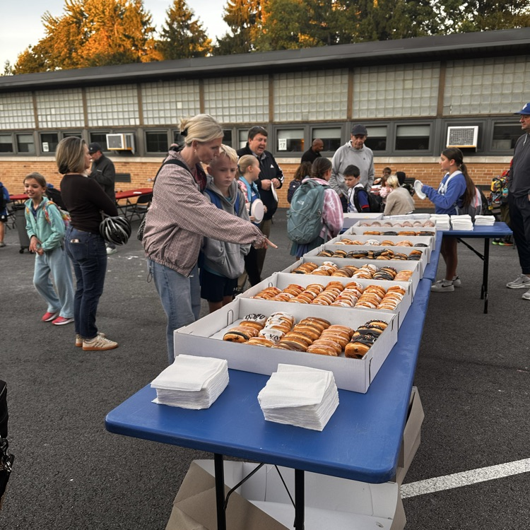 my mom and her son pointing at a table of donuts.