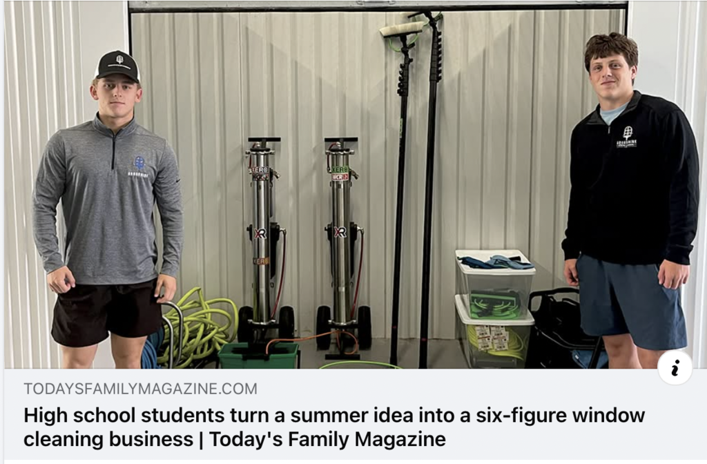 Two high school boys standing with window washing equipment.