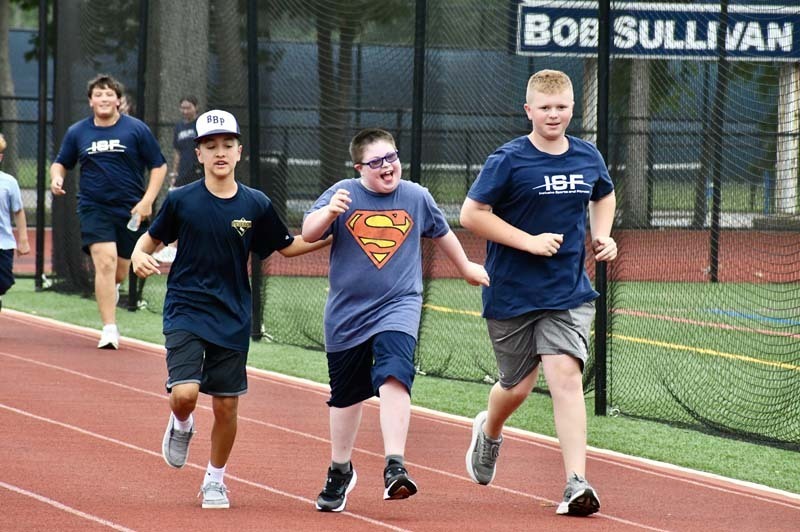 Students running on track outside.