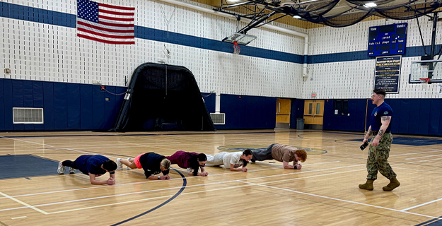 Students doing push-ups in gymnasium.