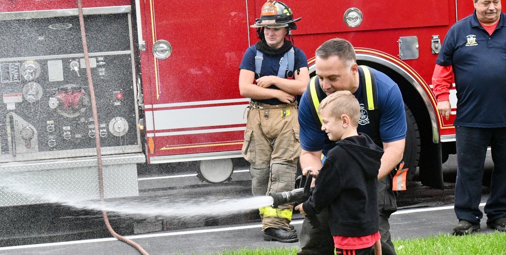 student with firefighter hose