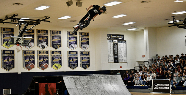 Ramp in gymnasium with students in stands,