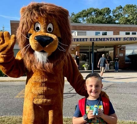 Student smiling with mascot.
