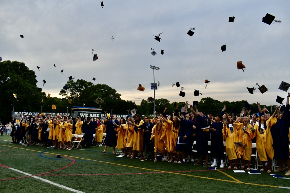 Students throwing their graduation caps into the air.