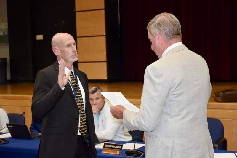 Board member being sworn in.