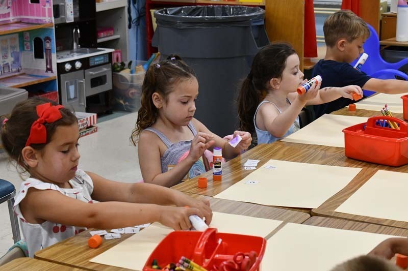 Student smiling while working on art project.