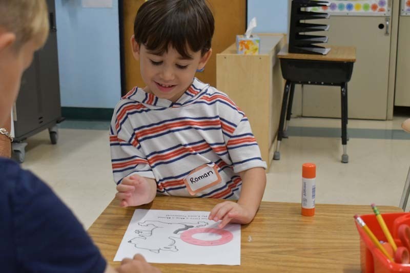 Student smiling while working on art project.