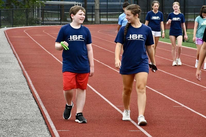 Students walking on track outside.