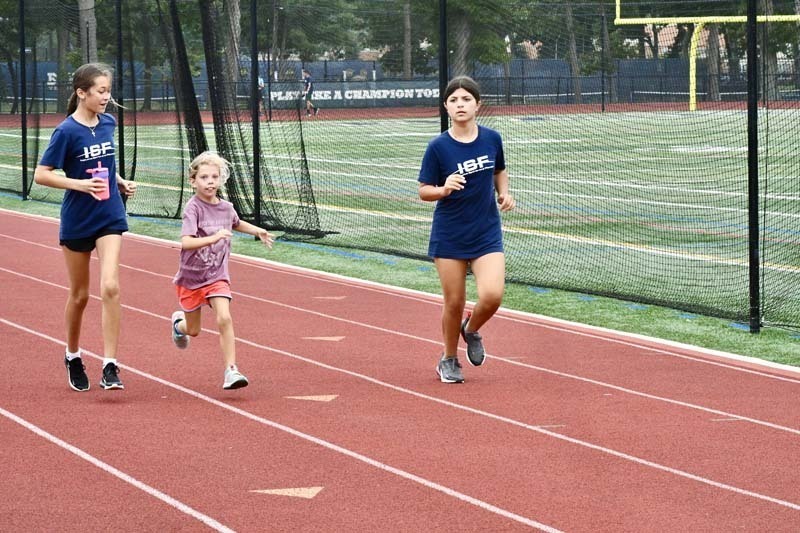 Students running on track outside.