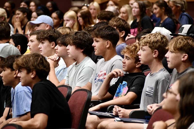 Students listening in auditorium.
