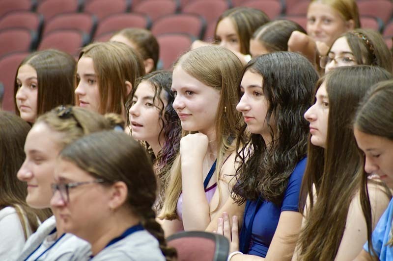 Students listening in auditorium.