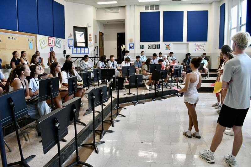Students listening in auditorium.