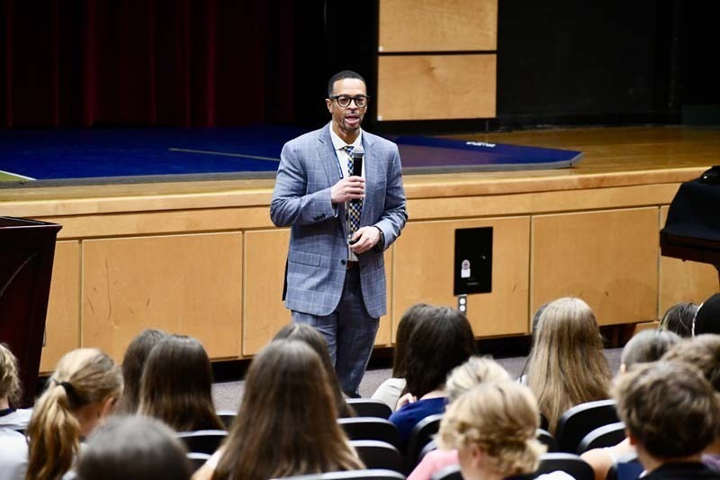 Man giving speech in auditorium.