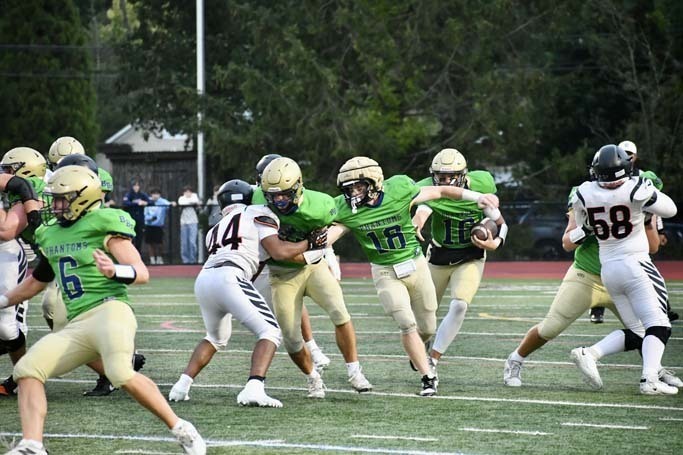 Student football players playing on field.