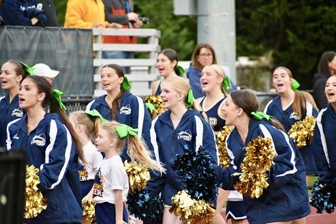 Student cheerleaders walking on track.