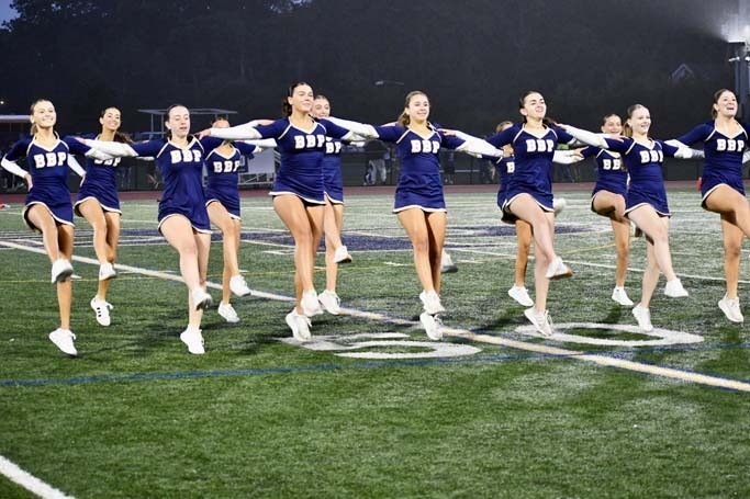 Cheerleaders performing on field.