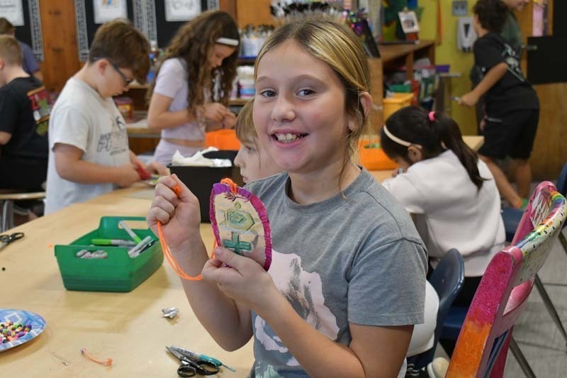 Student proudly holding what they made.