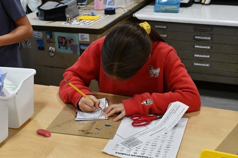 Student writing on paper.
