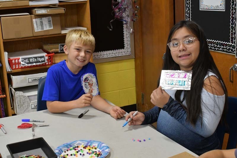 Students proudly showing off their work.