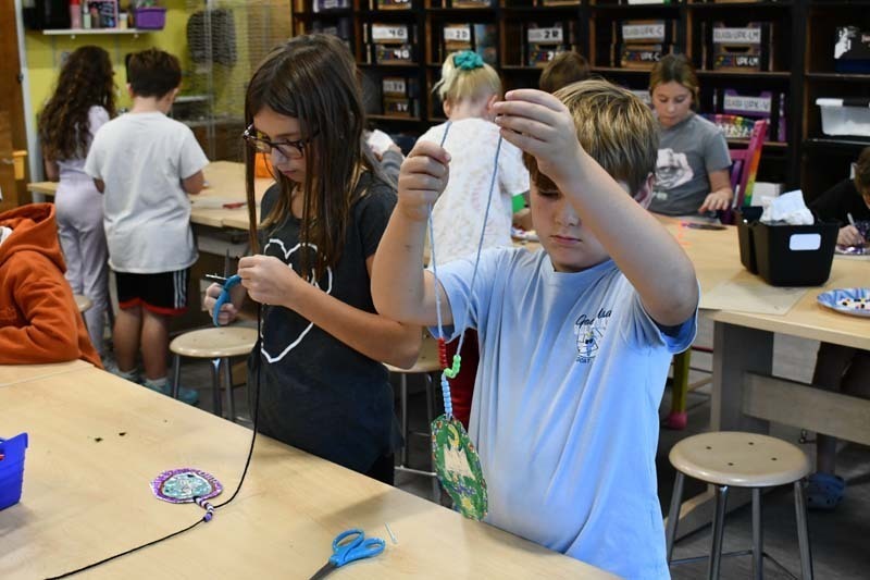 Students working, holding string in the air to cut and measure.