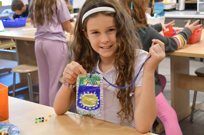 Student proudly holding badge.