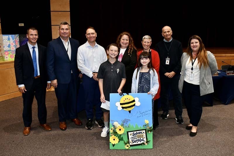 Students smiling with board members.